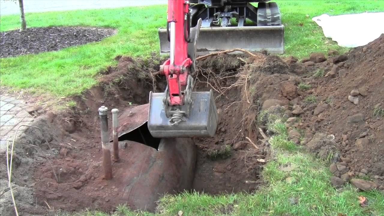 Bulldozer digging up and removing a hidden underground oil tank from a home in NJ
