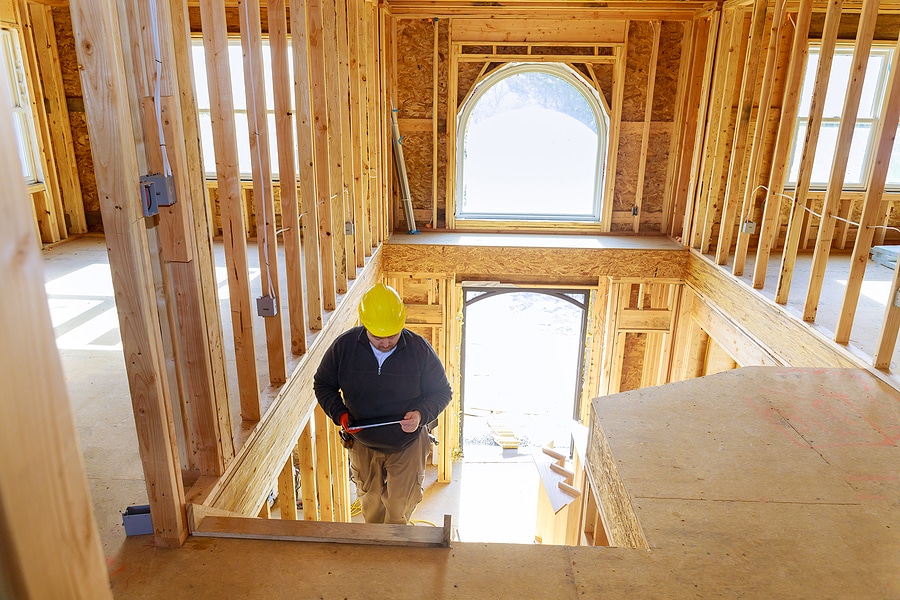 Man in hard hat inspecting a newly constructed home